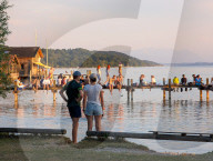 People Enjoy Summer Sunset At Lake