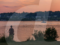 Man Enjoying The Sunset By Lake