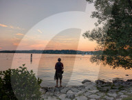 Man Enjoying The Sunset By Lake