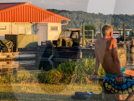 Man Sunbathing On A Bench By Lake