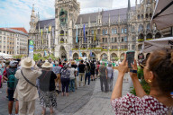 Tourists Watch The Carillon In The Tower Of The New Town Hall In Munich