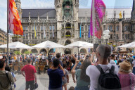 Tourists Watch The Carillon In The Tower Of The New Town Hall In Munich