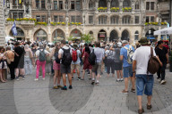 Tourists Watch The Carillon In The Tower Of The New Town Hall In Munich