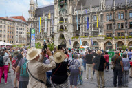 Tourists Watch The Carillon In The Tower Of The New Town Hall In Munich