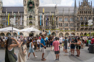Tourists Watch The Carillon In The Tower Of The New Town Hall In Munich