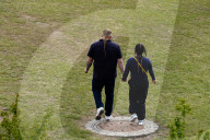 Couple Walking Hand In Hand Across A Meadow