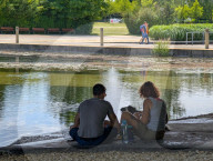 Young Couple Sitting By Stream In Shade