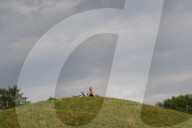 Man Sitting With Bicycle On Hilltop In Munich Park