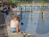 People Relaxing On The Shores Of Lake