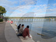 People Relaxing On The Shores Of Lake