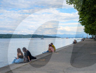 People Relaxing On The Shores Of Lake