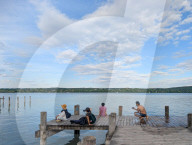 People Relaxing On The Shores Of Lake