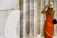 Woman In Orange Dress At Stone Columns