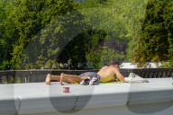 Man Sunbathing On Bridge Structure