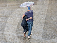 Couple Walking In Heavy Rain Under Umbrella