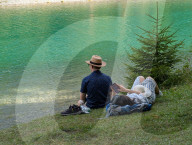 Couple With Smartphone By Water In Summer