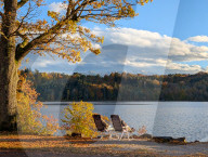Senior Couple Enjoying Autumn Sun By Lake