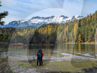 Hikers Admire Lake Weissensee And Snow-Capped Wetterstein Mountains In Tyrol