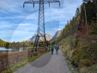 Hikers Walk At Lake Weissensee In The Tyrolean Alps