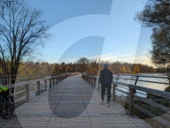 People In Autumn On The Flauchersteg Footbridge Over The Isar River In Munich