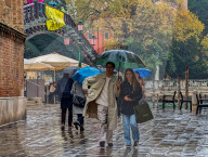 Elegantly Dressed Young Couple Walks In Rain With Shopping Bag In Venice