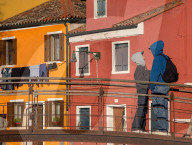 Young Couple Gazes On Bridge Against Colorful Burano Houses