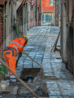 Construction Worker Repairs Pavement In Venice Alley