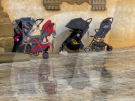 Baby Strollers Parked On Wet Pavement