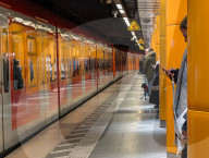 Commuter Holds Smartphone Next To S-Bahn Train At Marienplatz In Munich